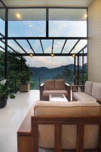 a living room with a couch and a large window at The Chillout Ella in Ella