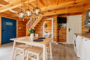 a kitchen with a table and chairs in a cabin at Nini House Giże in Giże