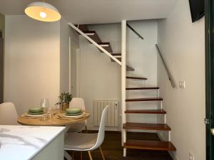 a kitchen and dining room with a spiral staircase at Casa Caracol in Cambados
