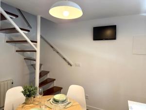 a dining room with a table and chairs and a staircase at Casa Caracol in Cambados