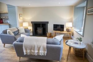 a living room with two couches and a fireplace at Riverside Cottage in Comrie