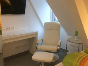 ein Wohnzimmer mit einem Stuhl und einem TV in der Unterkunft Apartment Deluxe Baden-Baden in Baden-Baden