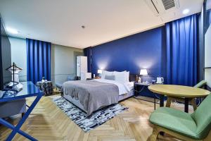 a hotel room with a bed and a table and chairs at js 부티크 호텔 동탄 in Hwaseong