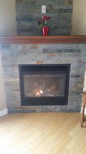 a stone fireplace with a fire in it at Condo St Sauveur in Piedmont