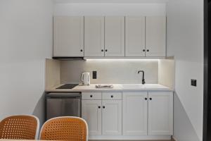 a kitchen with white cabinets and a sink at Giorgos apartments in Dassia