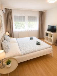 a bedroom with a large bed with two shoes on it at VeloVibe apartman in Balatonalmádi