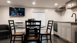 a kitchen with a table and chairs and a tv on the wall at Lake George Residence LLC in South Glens Falls