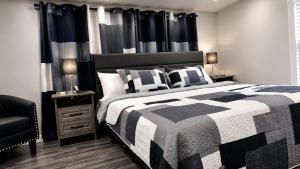 a bedroom with a black and white bed and a chair at Lake George Residence LLC in South Glens Falls +27 photos