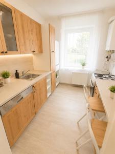 a kitchen with wooden cabinets and a sink at VeloVibe apartman in Balatonalmádi