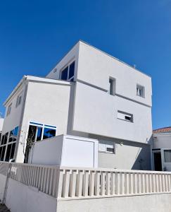 a white house with a fence in front of it at Vip Villa Tina in Novalja
