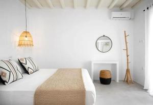 a white bedroom with a bed and a mirror at Felicia Exclusive Villa - Private Pool in Arnados