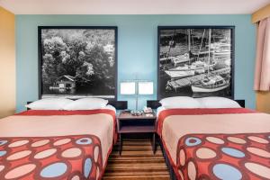 a hotel room with two beds and a table at Super 8 by Wyndham Thunder Bay in Thunder Bay
