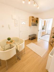 a living room with a glass table and chairs at VeloVibe apartman in Balatonalmádi