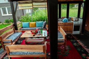 a screened in porch with a table and a kitchen at Wildmont Prokletije in Gusinje