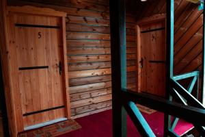 an empty room with two doors in a cabin at Wildmont Prokletije in Gusinje