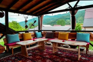 a room with couches and tables in front of a window at Wildmont Prokletije in Gusinje