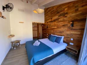 a bedroom with a blue bed with a wooden wall at Vida Pura Guesthouse in Odeceixe