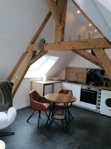 a kitchen with a table and chairs in a room at Auberge a la Ferme in Surques
