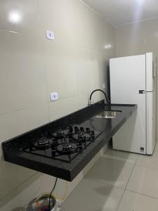 a kitchen with a stove and a white refrigerator at Lar caminho da Ilha in Igarassu