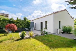 a white house with a lawn in front of it at Chambre - Le Nid in Saint-Prouant