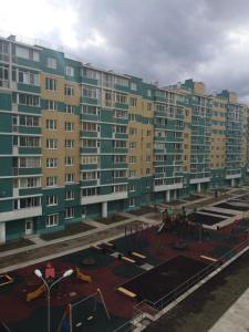 a large apartment building with a playground in front of it at Apartment Ozernaya 7 in Tver