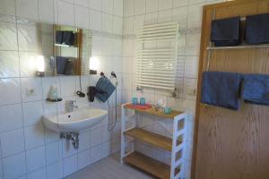 a white bathroom with a sink and a mirror at Apartment "An der Süderschmiede" in Sieverstedt