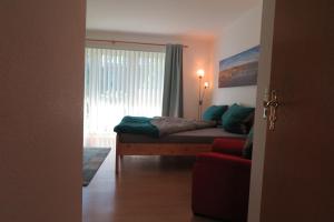 a bedroom with a bed with a window and a red couch at Apartment "An der Süderschmiede" in Sieverstedt