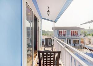 a balcony with two chairs and a view of a house at Sabbia Rossa Beach Resort in Arambol +5 photos