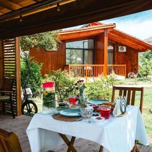 a table with a white table cloth on a porch at Mesopotam Agrotourism Resort in Sarandë