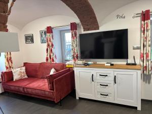 a living room with a red couch and a flat screen tv at Słoneczne Apartamenty in Sokołowsko