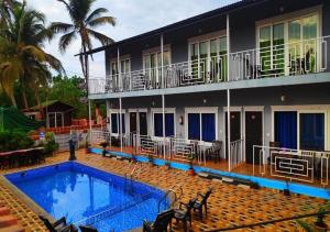 a house with a swimming pool next to a building at Sabbia Rossa Beach Resort in Arambol