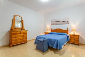 a bedroom with a bed and a dresser and a mirror at Ático en Candelaria 1 in Candelaria