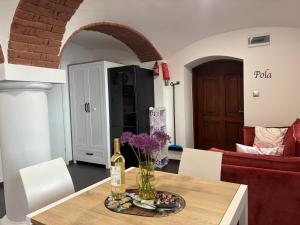 a table with a bottle of wine and flowers on it at Słoneczne Apartamenty in Sokołowsko