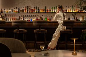 a woman is sitting on a bar stool at Okinawa Harborview Hotel in Naha