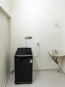 a bathroom with a sink and a small refrigerator at SK Aarshan's Homestay in Tiruchirappalli +10 photos