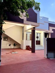 a large white house with a large patio at SK Aarshan's Homestay in Tiruchirappalli