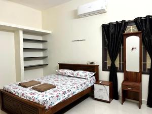 a bedroom with a bed and a dresser and a mirror at SK Aarshan's Homestay in Tiruchirappalli