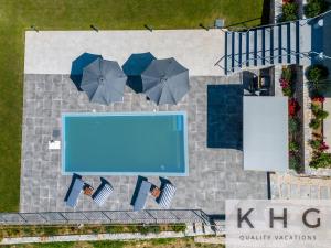 an overhead view of a swimming pool with umbrellas at Villa Guapa in Kardhakáta