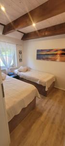 a bedroom with two beds and a painting on the wall at Ferienhaus Landidyll in Fehmarn