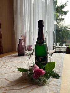 a bottle of wine sitting on a table with glasses at First Tee am Rosarium in Sangerhausen