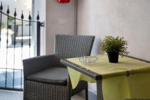 a table and a chair with a plant on it at Affitta Camere Novara in Novara