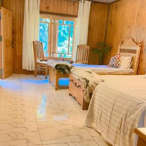 a bedroom with two beds and a table and chairs at The Royal Peaks in Kundālshai