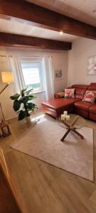 a living room with a red couch and a table at Ferienhaus Landidyll in Fehmarn