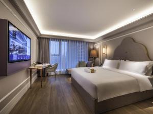 a hotel room with a large bed and a tv at Mercure Chengdu Chunxi Taikoo Li -Walk to Pedestrian Street in Chengdu +102 photos