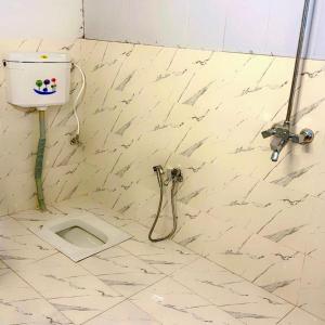 a tiled bathroom with a toilet in the floor at The Royal Peaks in Kundālshai