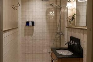 a tiled bathroom with a sink and a shower at Krusenberg Herrgård in Krusenberg +49 photos