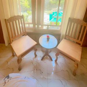 two chairs and a glass table in a room at The Royal Peaks in Kundālshai +8 photos