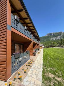 a building with flowers on the side of it at Riverside - Mountain Stay with Sauna in Vusanje