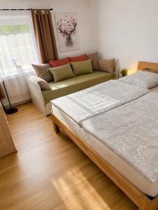 a living room with a bed and a couch at Schwarzwaldliebe mit Garten & Sauna in Gaggenau