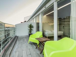 a balcony with green chairs and a table at Ibis Styles Lisboa Centro Marquês de Pombal in Lisbon +102 photos